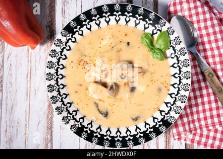 Une soupe de poulet et de champignons maison ou un fricassée de poulet à la française, dans un bol à soupe sur une table en bois. Vue aérienne Banque D'Images