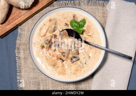 Une soupe de poulet et de champignons maison ou un fricassée de poulet à la française, dans un bol à soupe sur une table en bois. Vue aérienne Banque D'Images