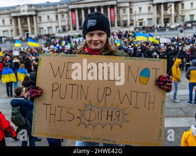 Londres, Royaume-Uni. 05 mars 2022. Une jeune fille tient un signe qui dit «NOUS NE SOMMES PAS POUTINE AVEC CE *Bullshit*» où le dernier mot est écrit en russe. La jeune fille fait campagne pour mettre fin à l'invasion russe de l'Ukraine, les drapeaux ukrainiens peuvent être vus en arrière-plan. © Matt Goodrum/Alamy Live News Banque D'Images