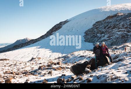 Deux personnes alpinisme dans un écosystème alpin sur un glacier enneigé Banque D'Images