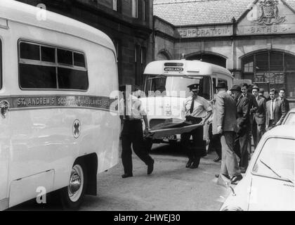 Tirez sur Holyrood Crescent à Woodside, Glasgow, où James Griffiths, âgé de 34 ans, a été assiégé dans son appartement du dernier étage par la police après avoir ouvert le feu avec un fusil et un fusil sur des personnes dans la rue. L'homme armé a finalement été abattu par la police après l'avoir encorré dans un bloc d'appartements suite à une poursuite de voiture de 60 km/h. spectacles d'images : des ambulanciers transportent le cadavre du tireur sur une civière après les 105 minutes de terreur. 16th juillet 1969. Banque D'Images