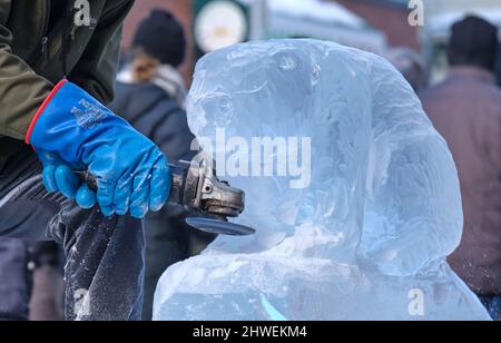 Dartmouth, Nouvelle-Écosse, Canada. 5th mars 2022. Des sculpteurs de glace au travail sculptant un spectacle de castors au Dartmouth Ice Carving Festival dans le centre-ville, un samedi après-midi ensoleillé. Banque D'Images