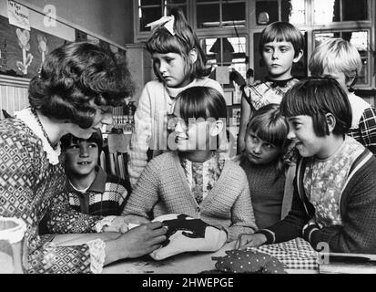 Avec leurs mères au travail dans l'usine Steinberg de Pontypridd, au pays de Galles, ont une leçon à faire du travail dans le besoin à une garderie payée par l'entreprise pour prévenir l'absentéisme chez leurs mères pendant les vacances scolaires. Des superviss formés ont été recrutés et payés par l'entreprise pour s'occuper de la classe de 25 garçons et filles à l'école secondaire du comté de Hawthorn située à proximité. Août 1969. Banque D'Images