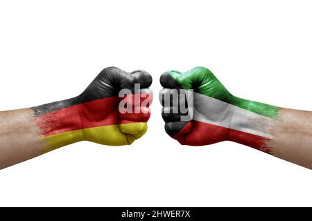 Deux mains poinçonner l'une à l'autre sur fond blanc. Les drapeaux de pays ont peint des poings, le concept de crise de conflit entre l'allemagne et le koweït Banque D'Images