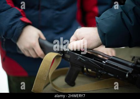 Assemblage du fusil d'assaut AK 47. Armes à feu fusil d'assaut Kalashnikov. Les gens ramassant le pistolet factice. Entraînement militaire. Banque D'Images