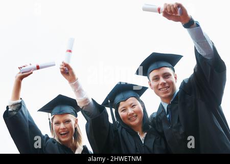 Nous étions sur le point de marquer notre marque sur le monde. Un groupe de jeunes diplômés enthousiastes qui détiennent leurs diplômes. Banque D'Images