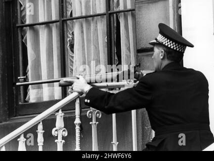 Tirez à Glasgow, où James Griffiths, 34 ans, a été assiégé dans son appartement du dernier étage par la police après avoir ouvert le feu avec un fusil et un fusil sur les gens dans la rue. Le tireur a finalement été tué par la police après l'avoir semé dans un bloc d'appartements à la suite d'une poursuite de 60 km/h. Sur la photo, un markman de police surveille le tireur dans son grenier au début de la bataille. 15th juillet 1969. Banque D'Images