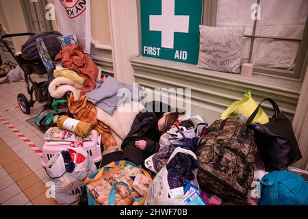 Przemysl, Pologne. 05th mars 2022. Un réfugié épuisé est vu à l'intérieur de la gare. Des centaines de milliers de réfugiés d'Ukraine continuent d'arriver à la ville frontalière polonaise de Przemysl le 10th jour de l'invasion russe. Crédit : SOPA Images Limited/Alamy Live News Banque D'Images