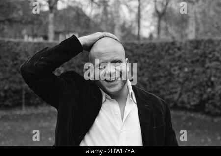 Oliver Reed porte sa perruque chez lui à Wimbledon, dans le sud-ouest de Londres. 29th novembre 1970.Oliver Reed, à ce moment-là, filme The Devils, un film de Ken Russell, où il joue un prêtre de 17th siècles injustement accusé de saucerie par un groupe de religieuses. Dans le film, Reed apparaît chauve, et tandis que la production est en cours, la compagnie de film a fait de lui une perruque de 200 livres à porter. Cependant, il préfère faire face au monde chauve et refuse donc du porter. Il a également rasé ses sourcils, sa barbe et sa moustache pour le film réalisé aux Pinewood Studios. La compagnie de film a pris une assurance de 250 livres Banque D'Images