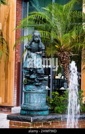 Fontaine et statue d'une fille chassant des papillons sur la promenade de Savannah Riverwalk, Géorgie. Banque D'Images