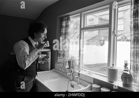 Le comédien Ken Dodd ouvre des appartements à Ducie Street et Beaconsfield Street, Toxteth, Liverpool. Deux maisons, une dans chaque rue, ont été converties en appartements sous la direction d'une équipe d'experts en logement et en planification. Ken boit une tasse d'eau dans la nouvelle cuisine de Mme Mrgaret Gibbs, rue Ducie. 7th avril 1970. Banque D'Images