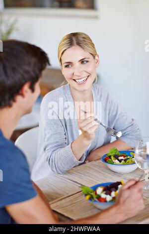 Une alimentation saine pour passer une saine pour toujours ensemble. Photo d'un jeune couple heureux en dégustant une salade saine ensemble. Banque D'Images