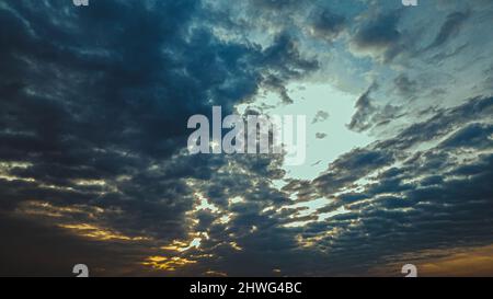 Un coucher de soleil illumine les nuages avec de belles couleurs pendant que le soleil se couche. Banque D'Images