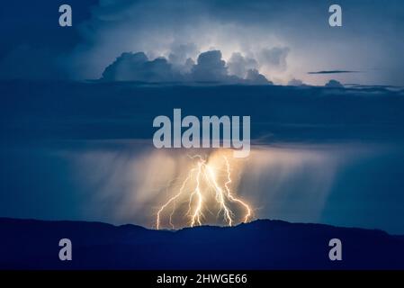 La foudre frappe sur un sommet de montagne pendant une tempête Banque D'Images