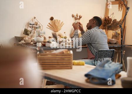 potier concentré vérifiant la texture de la surface du produit en poterie Banque D'Images