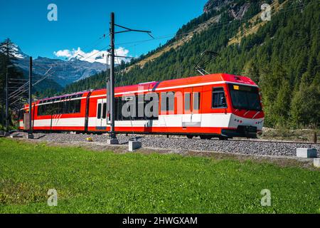 Chemin de fer de montagne avec un train moderne de passanger rouge dans les Alpes. Un des plus beaux chemins de fer d'Europe, canton du Valais, Suisse Banque D'Images