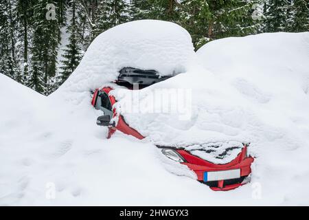 une voiture rouge recouverte de neige Banque D'Images