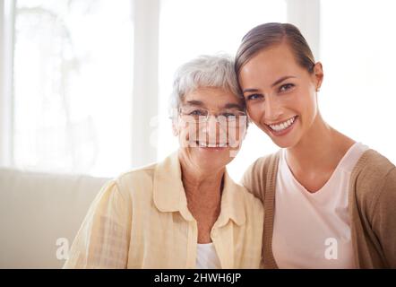 Shes mon rocher. Portrait d'une jeune femme souriante et de sa mère âgée qui se joint. Banque D'Images