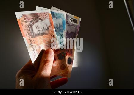 Gros plan d'un homme âgé qui détient plusieurs livres sterling Banque D'Images