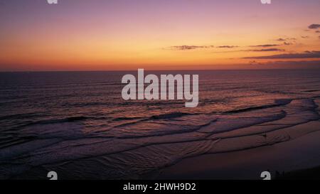 Les gens apprécient le coucher de soleil romantique à la célèbre plage Echo Beach à Canggu, sur l'île tropicale de Bali. Tourisme assis et marcher sur la plage à Canggu Banque D'Images