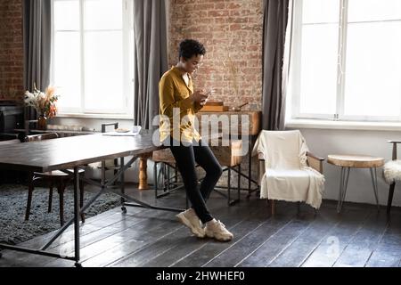 Une jeune fille d'entrepreneur positive et concentrée debout à une grande table de travail Banque D'Images