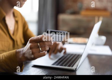 Femme tenant la main avec la carte de crédit à l'ordinateur portable de près Banque D'Images