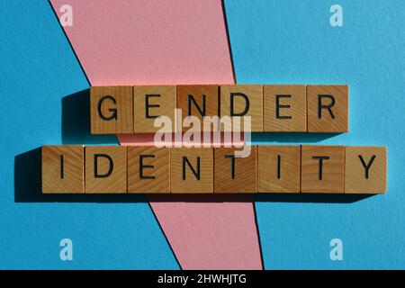 Identité de genre, mots en lettres de l'alphabet en bois isolées sur fond rose et bleu Banque D'Images