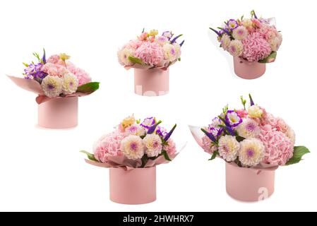 Bouquet de fleurs rose et violet dans une boîte rose isolée sur fond blanc. Banque D'Images