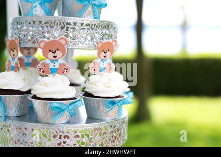 Gâteau en bleu et blanc et petits gâteaux pour l'anniversaire des enfants ou baptême sur une table douce pour une fête de jardin Banque D'Images