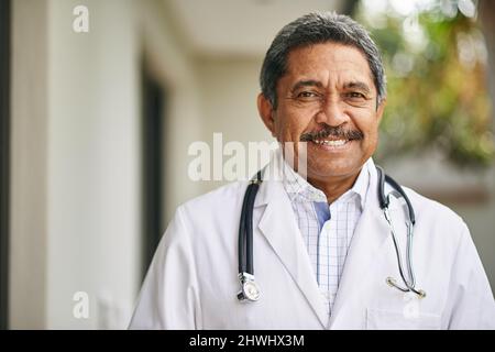 Heureux de vous aider à récupérer. Portrait d'un médecin mâle mature debout à l'extérieur. Banque D'Images