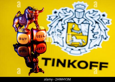 Le taureau métallique se dresse sur des dés d'achat-vente sur le fond du logo de la banque de Tinkoff Banque D'Images