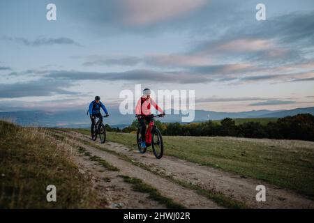 Couple senior actif à vélo en plein air dans la nature en automne. Banque D'Images