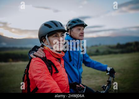 Couple senior actif à vélo en plein air dans la forêt en automne. Banque D'Images