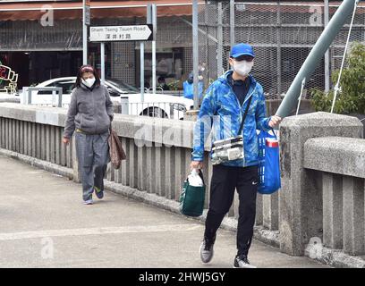 Hong Kong. 6th mars 2022. Des personnes portant des masques de visage marchent dans une rue dans le sud de la Chine Hong Kong, le 6 mars 2022. Crédit : Lo Ping Fai/Xinhua/Alamy Live News Banque D'Images