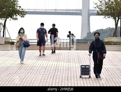 Hong Kong. 6th mars 2022. Des personnes portant des masques de visage marchent dans une rue dans le sud de la Chine Hong Kong, le 6 mars 2022. Crédit : Lo Ping Fai/Xinhua/Alamy Live News Banque D'Images