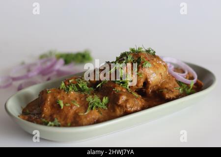 Curry de poulet préparé au poulet avec de la sauce à la noix de cajou et des feuilles de coriandre fraîches. Prise de vue sur fond blanc Banque D'Images