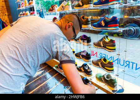 Amsterdam, Hollande, Chinois homme Shopping pour « New Balance » Inside Shop, vente de chaussures magasin de baskets Banque D'Images