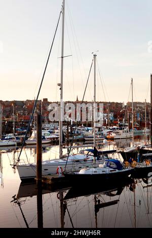 Bateaux de pêche à quai et bateaux de plaisance dans le port supérieur de Whitby sur la rivière Esk pris dans la rue de l'église au crépuscule, North Yorkshire, Angleterre, Royaume-Uni Banque D'Images