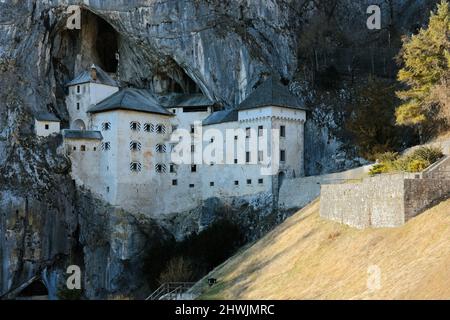 Vue de la fin de l'hiver sur le château de Predjama près de Postojna, en Slovénie, perché au milieu d'une grande falaise et relié à un système de grottes Banque D'Images