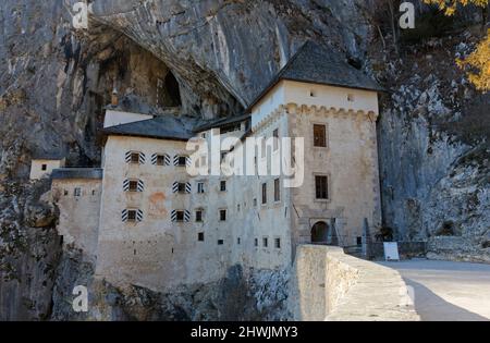 Vue de la fin de l'hiver sur le château de Predjama près de Postojna, en Slovénie, perché au milieu d'une grande falaise et relié à un système de grottes Banque D'Images