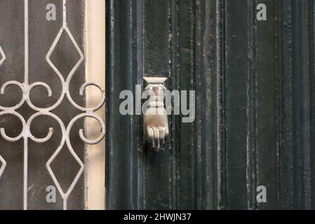 Ancienne maison néoclassique Faded cyprès porte d'entrée en bois vert avec des grilles en fer forgé fabriquées à la main et un ancien knocker en laiton à Nafplio, Grèce. Banque D'Images