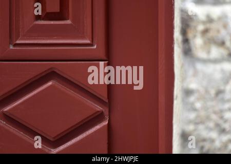 Ancienne maison néoclassique porte en bois rouge contre un mur en pierre à Nafplio Grèce. Banque D'Images