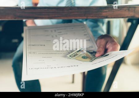 Les hommes attachent de l'argent aux demandes d'emploi. Un homme soudoiement pour un nouvel emploi. Poste vacant, concept de candidature. Banque D'Images