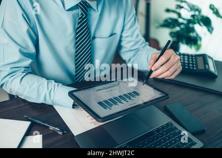 Tablette numérique à écran tactile avec stylet et plan d'activité sur l'espace de travail de la table. Banque D'Images