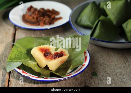 Kue Bugis ou Kue Mendut, en-cas traditionnel indonésien à base de farine de riz gluant, farci de noix de coco râpée et enveloppée dans une feuille de banane. P Banque D'Images