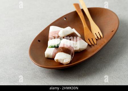 Getuk Tigna Warna ou Getuk Trio, en-cas javanais traditionnel sucré de Magelang. Un mélange de manioc et de noix de coco, servi sur une assiette en céramique brune Banque D'Images