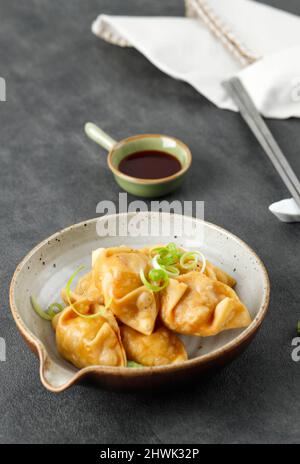 Sélection de mandu frit de Dumpling coréen Focus sur une assiette, servi avec une sauce épicée Banque D'Images