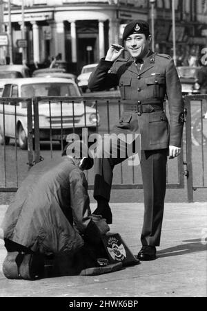 Le Caporal Brian Baker des Royal Marines, qui vient de Newcastle, est vu à Londres avoir un polissage rapide de ses bottes par Stuart Redmand, qui est un polisseur de chaussures régulier de Piccadilly à Londres. Avril 1972 P035498 Banque D'Images