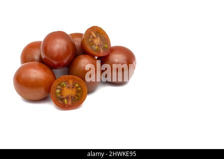 Un lot de tomates cerises, la petite variété de kumato. Isolé sur fond blanc. Banque D'Images