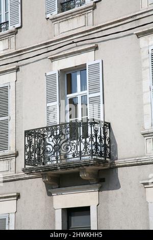 Balcon typique de construction d'appartements français, avec des décorations en fonte et des volets à persiennes pour bloquer le soleil de l'après-midi Banque D'Images